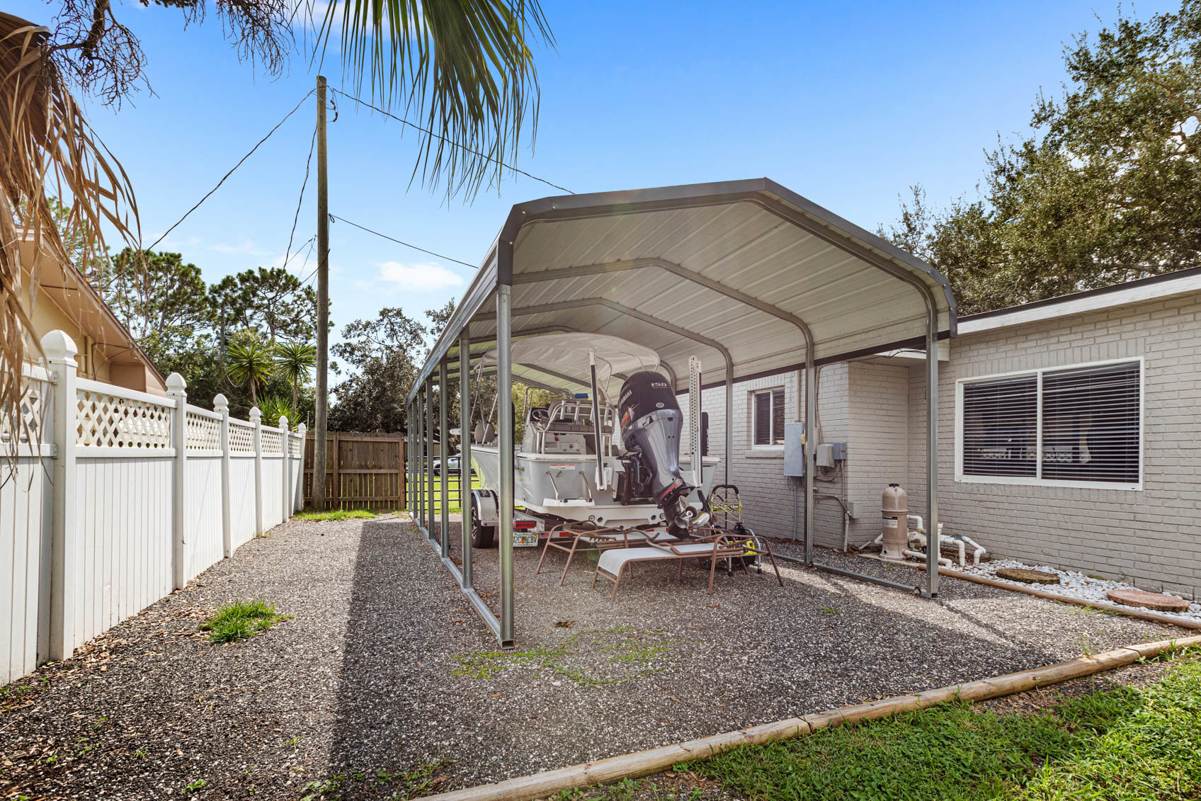 carport with boat and gravel